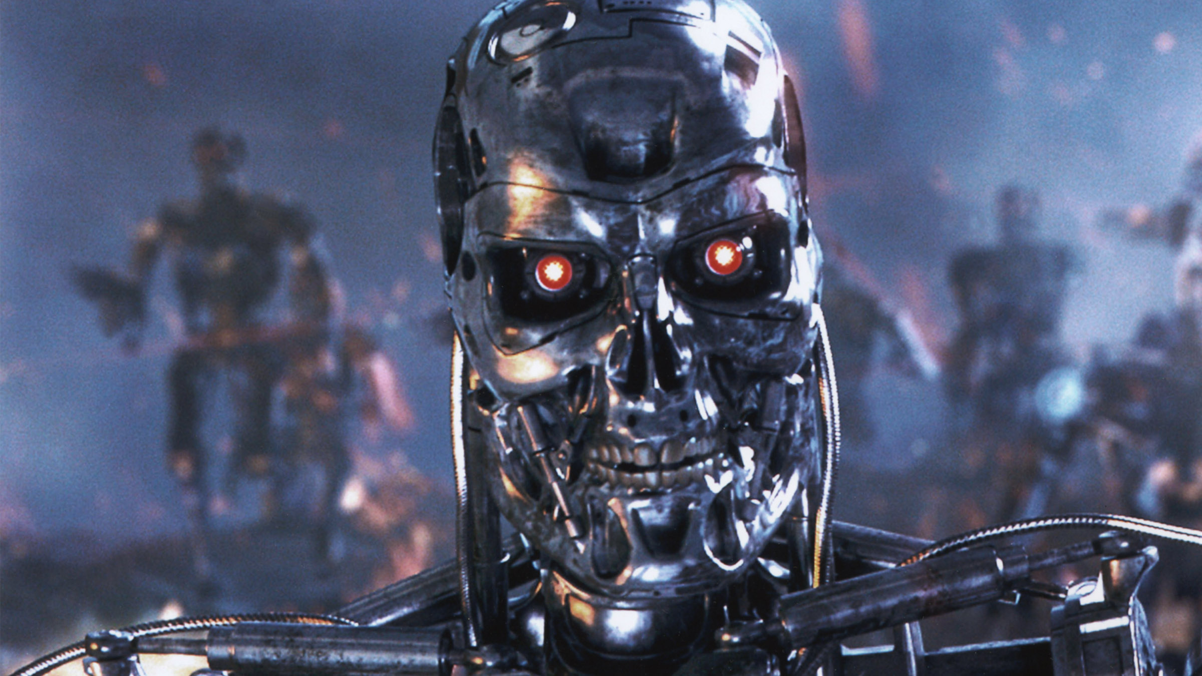 T-800 from The Terminator movie looking at camera with other robots in the background.