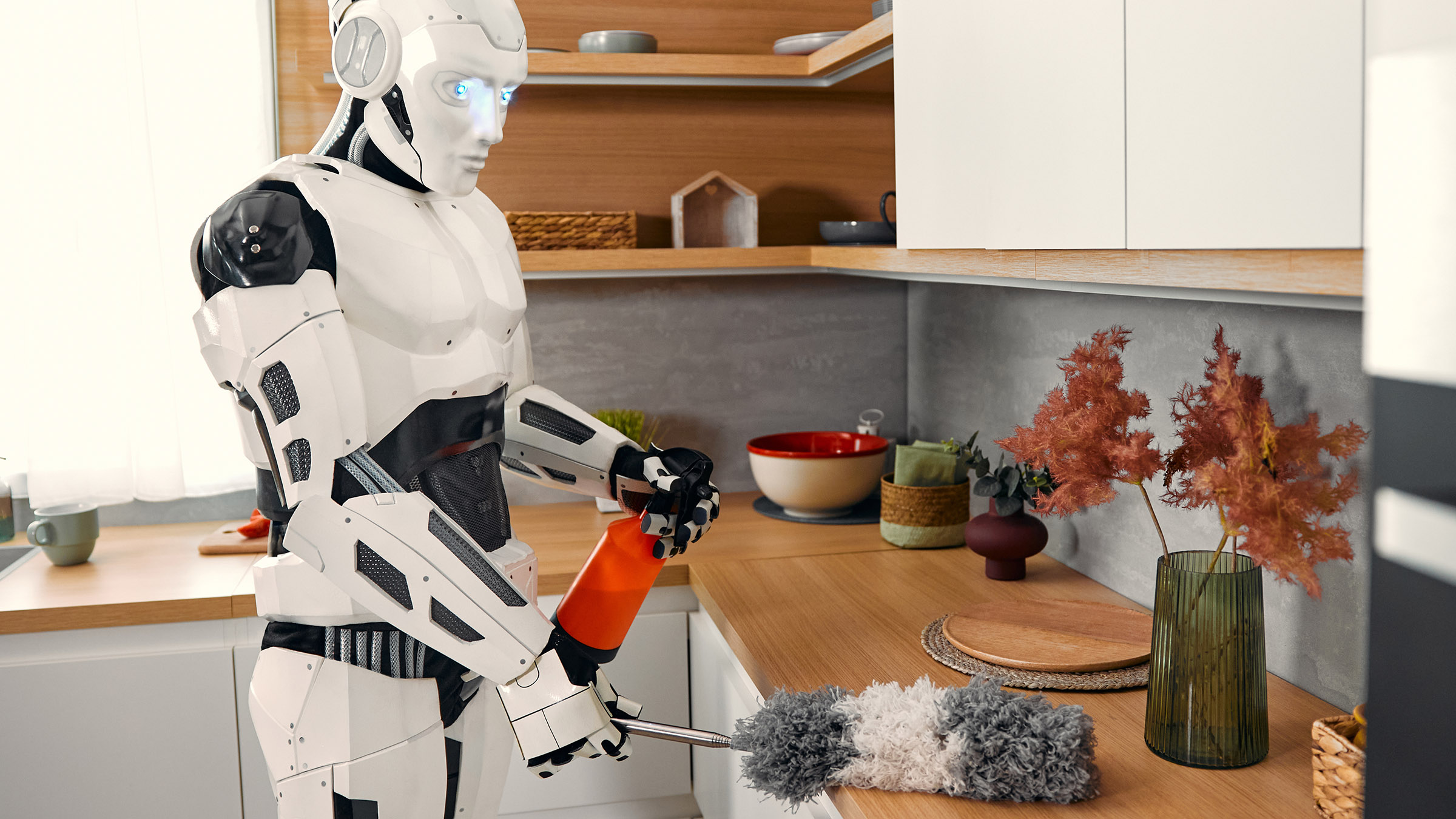 A digital illustration of a humanoid robot holding a spray bottle and a duster and cleaning a kitchen counter in a modern looking home.