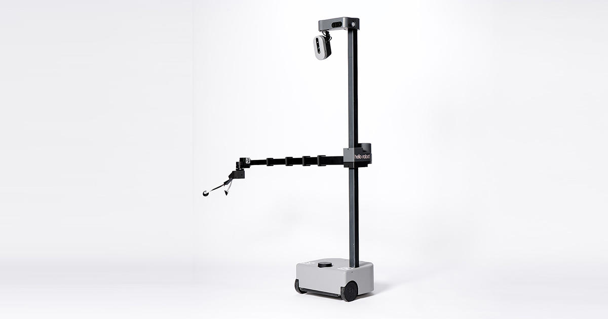 A robot consisting of a mobile base that carries a pole with a camera and an arm that can stretch stands against a white background.